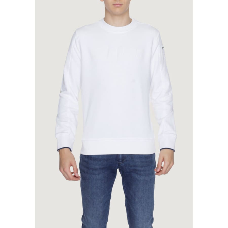Man in urban style clothing, white Blauer sweatshirt and jeans, showcasing urban city fashion