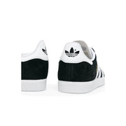 Adidas women black sneakers with black and white suede upper, rubber sole, lace up, and iconic three stripes