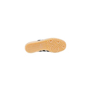 Adidas women white faux leather slip on sporty sneakers with black accents and tan rubber sole featuring textured pattern