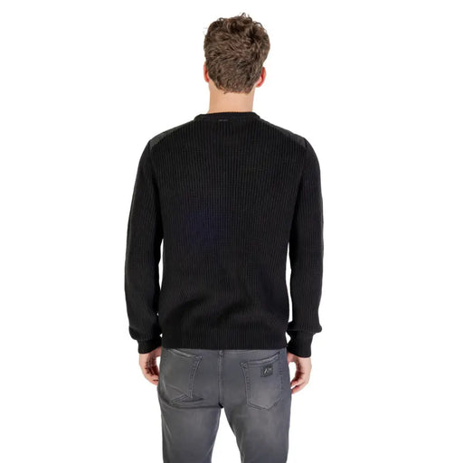 Black ribbed crew neck sweater with a subtle sheen, likely made of cotton or polyester blend.