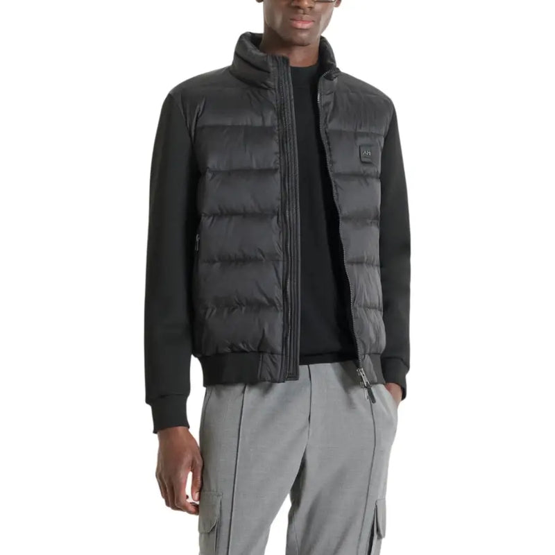 Black puffer vest with quilted design and zipper closure.