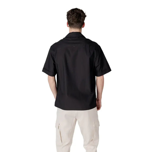 Men’s black short-sleeve V-neck shirt with pockets paired with light beige cargo pants