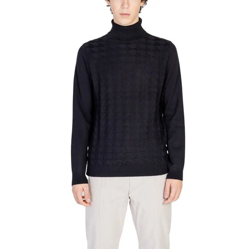 Black turtleneck sweater with geometric pattern and ribbed cuffs, likely made of wool or cotton blend.