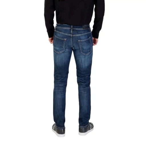 Blue denim jeans with distressed details and a slim fit.