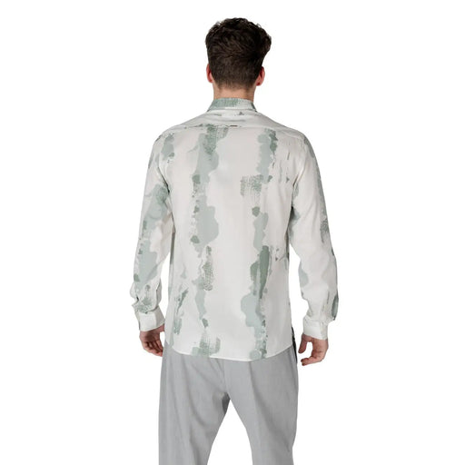 A man wearing an antony morato men green cotton blend shirt with green and gray paint splatter pattern