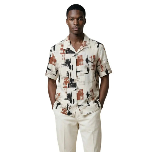 A man wearing an Antony Morato short-sleeved men shirt with black and rust-orange geometric pattern on cream background