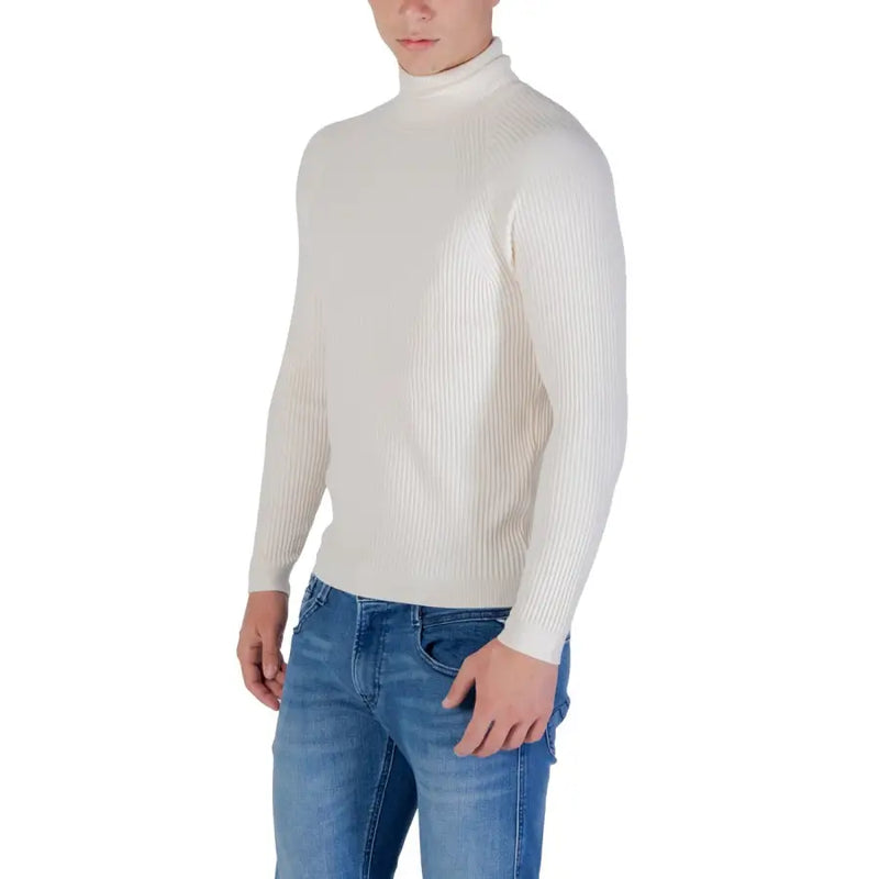 Cream ribbed turtleneck sweater with jeans and blue denim pants.