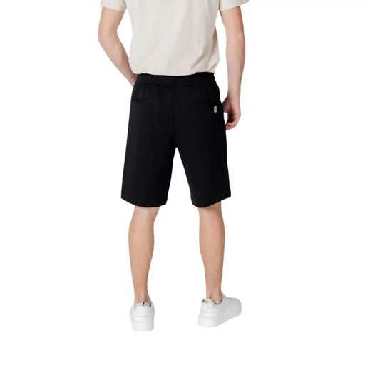 Black cotton shorts with white logo on the back pocket.