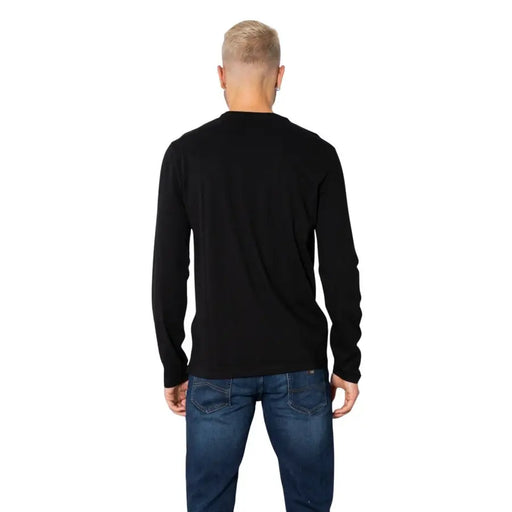 Men’s black long-sleeve crewneck cotton T shirt paired with blue jeans from Armani Exchange