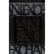 Black square metal plaque with embossed ax logo and armani exchange text on black print polyurethane handbag
