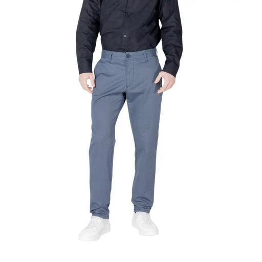 Men’s blue slim-fit cotton blend trousers paired with a black button-up shirt and white sneakers