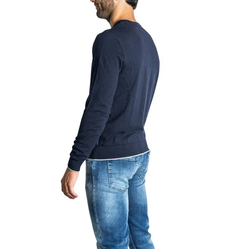 Navy blue long-sleeved crew neck t-shirt with distressed denim jeans and a casual, relaxed fit.