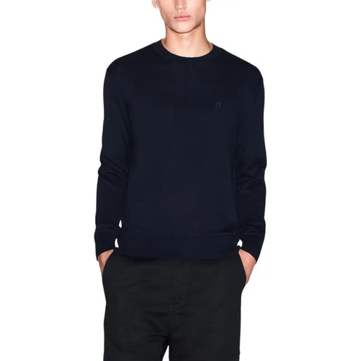 Navy blue cashmere crew neck sweater with a small embroidered logo on the left chest.