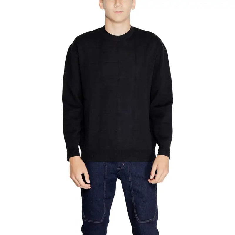 Black crewneck sweater with ribbed cuffs and hem, made of cotton.