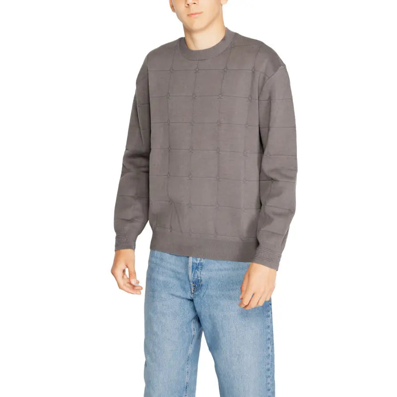 Charcoal gray sweater with a quilted design and ribbed cuffs, made of cotton.