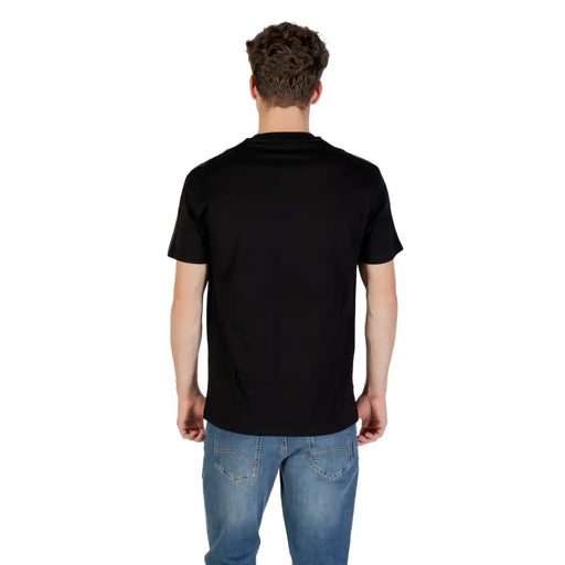 Men’s black short-sleeve round neck cotton T-shirt paired with blue jeans from Armani Exchange
