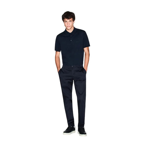 A man wearing an Armani Exchange men blue cotton short sleeve polo shirt with a subtle embroidered logo on the chest