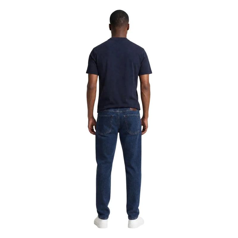 Dark blue denim jeans with classic straight-leg cut and visible stitching paired with armani exchange men blue cotton t shirt round neck