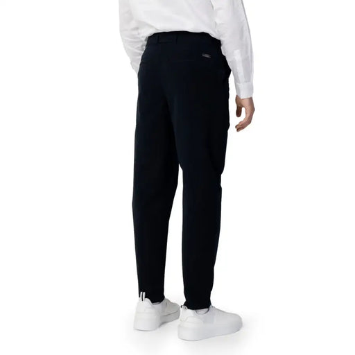 Men’s black trousers paired with white sneakers from Armani Exchange for spring summer style