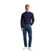 Ein Mann, der einen armani exchange Herrenhemd aus blauer Baumwolle mit geometrischem Muster und weißen Punkten sowie klassisch geschnittene Jeans