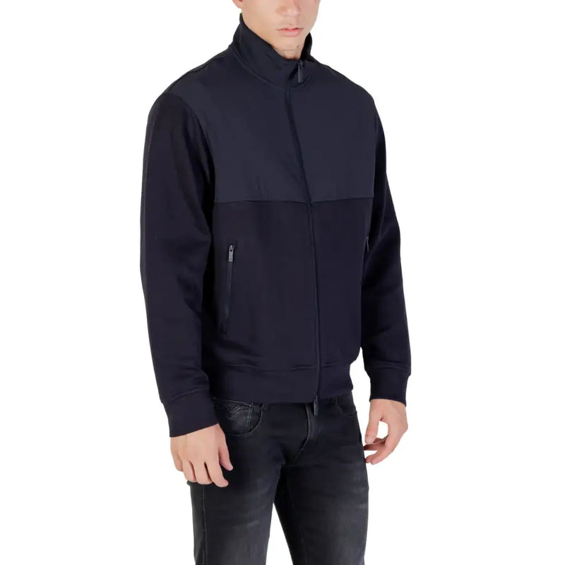 Men’s navy blue full-zip track jacket with stand-up collar and black jeans