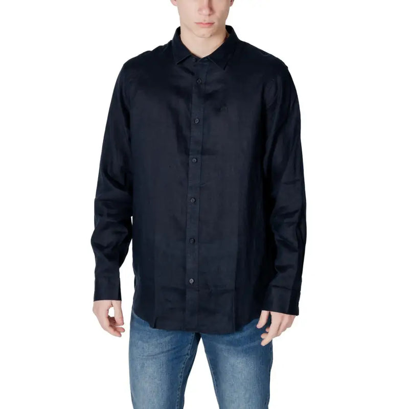 Men’s navy blue long-sleeved button-up shirt paired with blue jeans for spring summer style