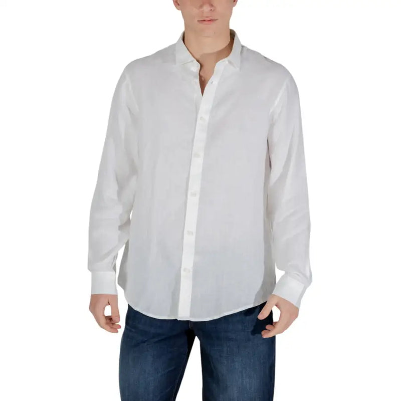 Men’s white long-sleeve button-up shirt paired with blue jeans for spring summer style