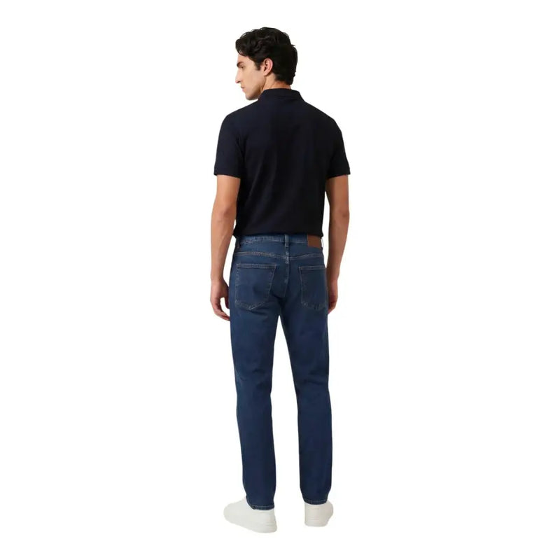 Jean en denim bleu foncé à cinq poches et empiècement en cuir marron, associé à armani exchange polo bleu zippé pour homme