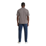 A man wearing an Armani Exchange men brown cotton t shirt paired with dark blue jeans