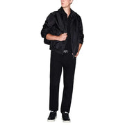Blouson aviateur noir texturé, légèrement brillant, avec poignets côtelés, idéal pour un look polo homme à manches courtes en coton.