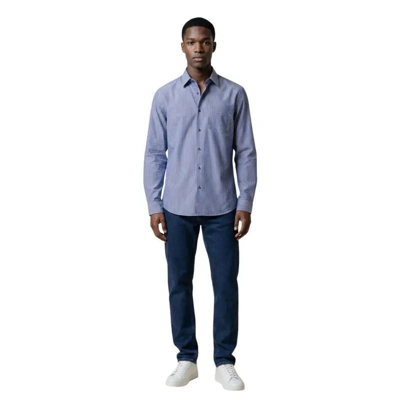A man wearing an Armani Exchange men shirt with blue and white vertically striped long-sleeved button-down design