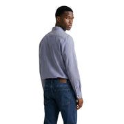A man wearing an Armani Exchange men shirt in blue and white striped long-sleeved button-down style