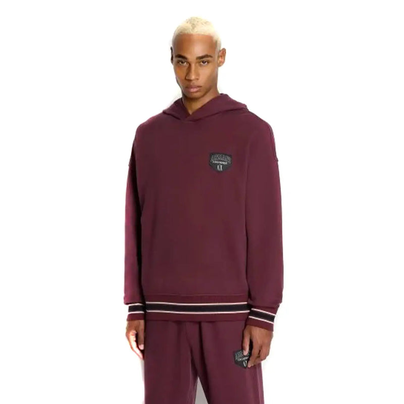 Armani Exchange Sweat-shirt homme bordeaux à capuche avec poche, logo Puma bordeaux et poignets rayés noirs et blancs.