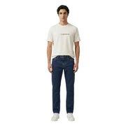 Ein Mann, der einen cremefarbenen Armani Exchange Männer t-shirt mit dezenter goldener Schrift und dunkelblauen Jeans