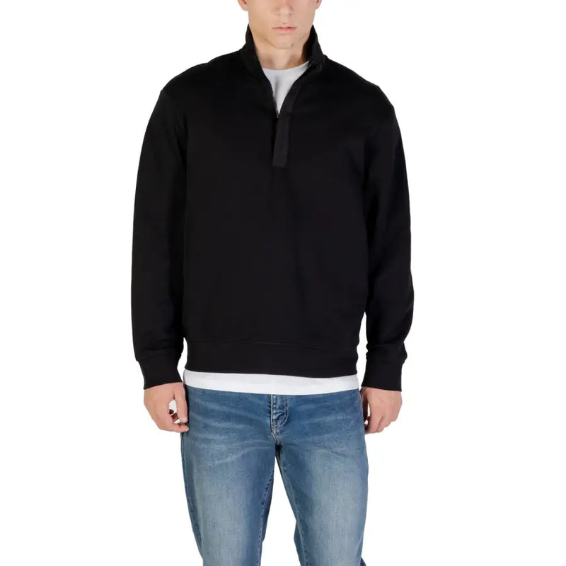 Men’s black quarter-zip sweatshirt with stand-up collar over white t-shirt and blue jeans