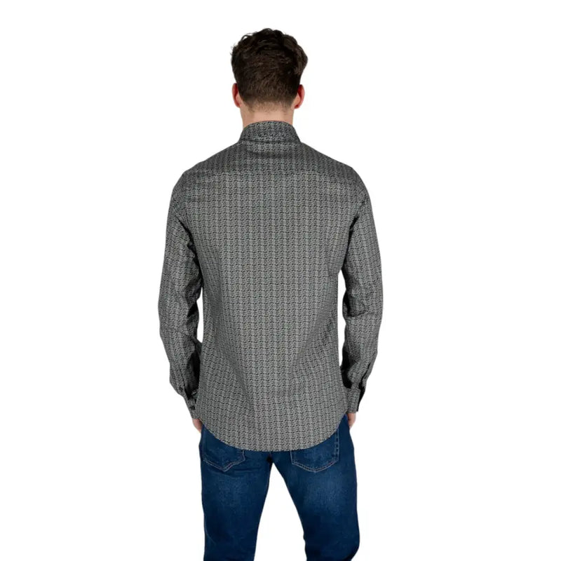 Ein Mann, der einen Armani Exchange Schwarzes Herren-Langarmhemd aus Baumwolle mit geometrischem Muster und dezentem Design