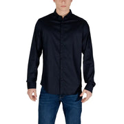 Men’s navy blue long-sleeved collared shirt with front buttons paired with blue jeans