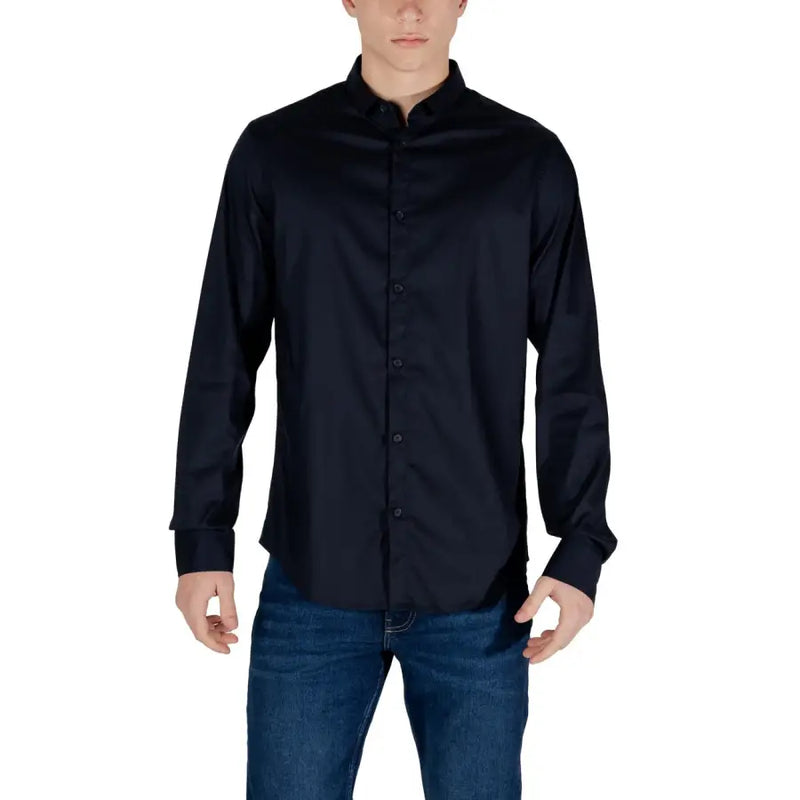 Men’s navy blue long-sleeved collared shirt with front buttons paired with blue jeans