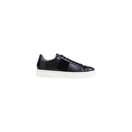 Schwarzes Leder niedrigtop Sneaker mit weißer Sohle und Riemenverzierung.