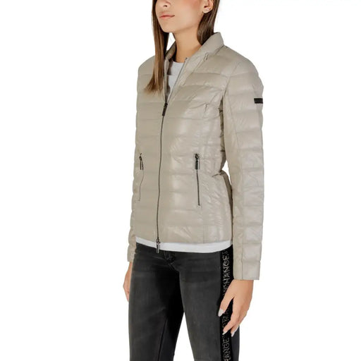 Woman wearing Armani Exchange beige quilted puffer jacket with high collar and zippered pockets