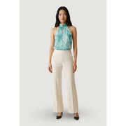 A woman wears Artigli women white wide-leg trousers with zip front pockets paired with a teal tie-dye halter top