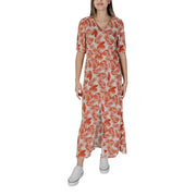 A woman wearing a b.young floral v-neck dress in brown with orange leaf pattern made of 100% viscose