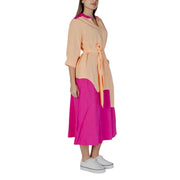 A woman wearing a b.young silver v-neck cotton dress with buttons, pockets, peach and fuchsia color-block design