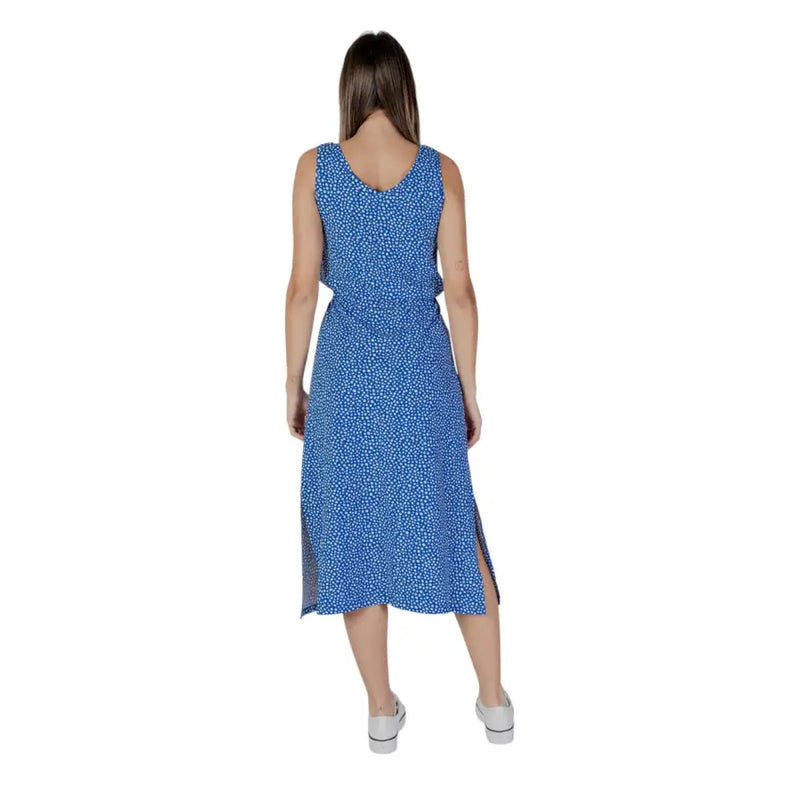 A blue sleeveless midi dress with white polka dot pattern and side slit by B.young