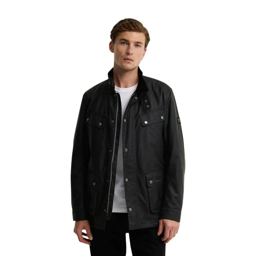 Veste en coton ciré noir avec boutons argentés et un discret logo sur la manche, signée Barbour International.