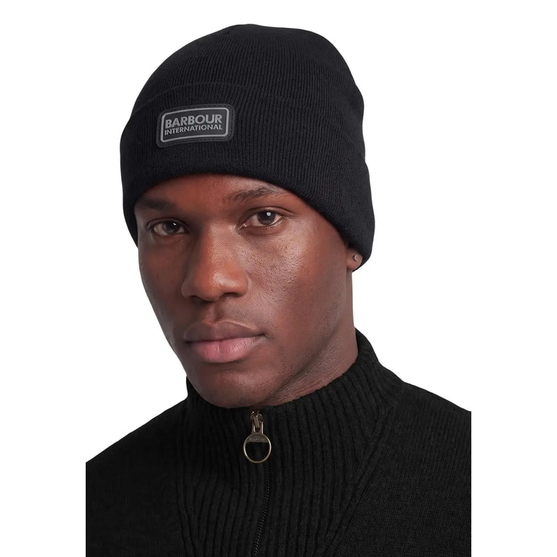 Barbour International Wollmütze für Herren, schwarz, gerippt, mit rechteckigem Logo-Aufnäher, Vorderansicht