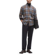 A man wearing a Barbour men shirt in brown gray and beige plaid with black cuffs and button-down design
