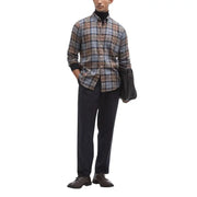 A man wearing a Barbour men shirt in brown gray and beige plaid with black cuffs and button-down design
