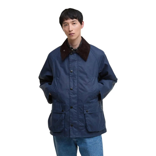 Der blaue Barbour Herrenblazer aus gewachster Baumwolle ist eine marineblaue Feldjacke aus gewachster Baumwolle mit dunkelbraunem Kragen und schwarzen Knöpfen.