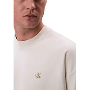 Beige crewneck sweatshirt featuring a cream-colored fabric with subtle gold embroidered Calvin Klein logo on chest